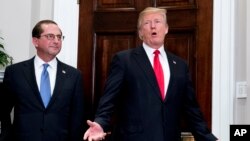 President Donald Trump, accompanied Health and Human Services Secretary Alex Azar (L), answers reporters' questions after participating in Azar's swearing in ceremony at the White House, Jan. 29, 2018.