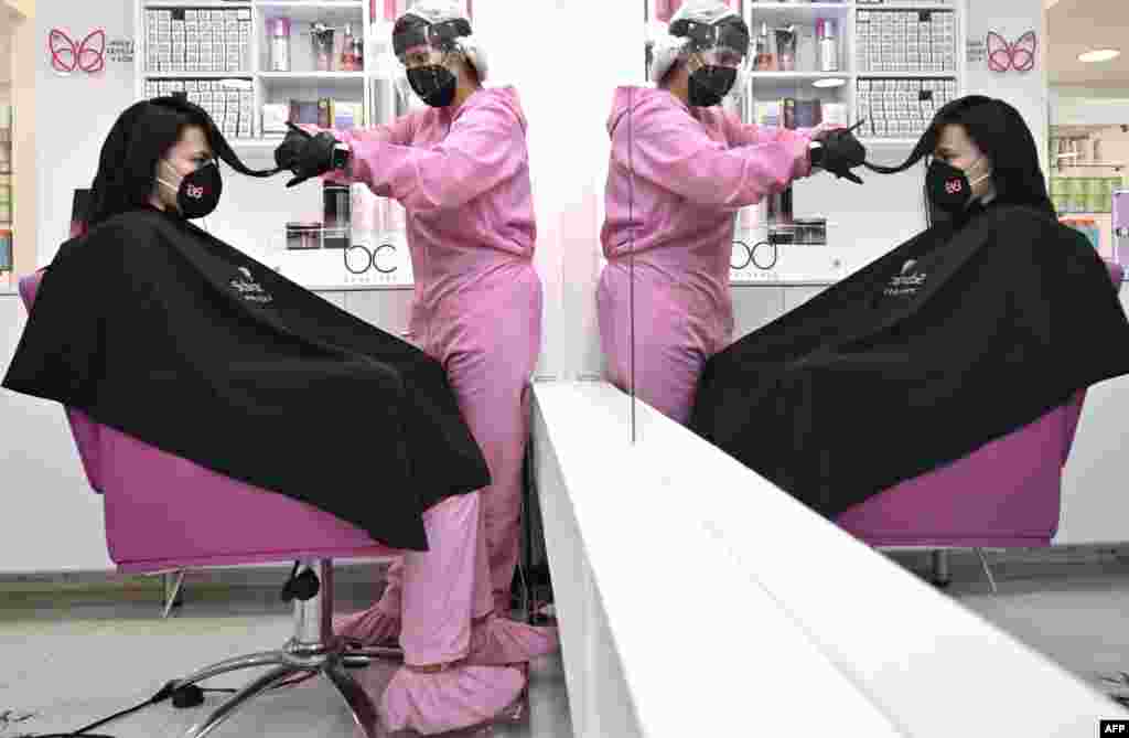 A stylist and a customer wear protective equipment as a preventive measure against the COVID-19 coronavirus, at a beauty salon in Bogota, June 23, 2020.