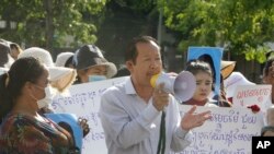 Rong Chhun, center, President of the Cambodian Trade Union Confederation, uses a megaphone during a protest near the prime minister's residence in Phnom Penh, Cambodia, Wednesday, July 29, 2020. (AP Photo/Heng Sinith)