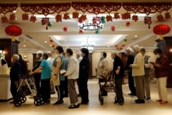 北京和悦家国际颐养社区的老人们排队吃午饭。（2021年5月26日）