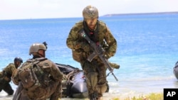 资料照：2017年5月13日，日本、法国、美国和英国在关岛海军基地举行联合军事演习，日本士兵使用橡皮筏作为两栖演习的一部分。(美联社图片)