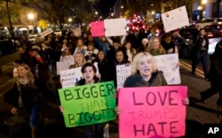 FILE - Demonstrators holds banners as they protest during a march in downtown Washington in opposition of President-elect, Donald Trump, Nov. 12, 2016.