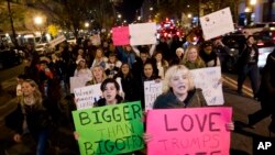 Demonstrators holds banners as they protest during a march in downtown Washington in opposition of President-elect, Donald Trump, Saturday, Nov. 12, 2016.