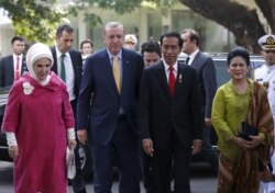 Presiden Indonesia Joko Widodo (kedua dari kanan) dan istrinya Iriana (kanan) berjalan bersama Presiden Turki Recep Tayyip Erdogan (kedua dari kiri) dan istrinya Emine (kiri) pada saat kedatangan mereka untuk upacara penyambutan di istana presiden di Jaka