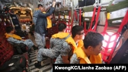 Republic of Singapore Air Force personnel (RSAF) servicemen on board a C-130 aircraft participating in the search and locate (SAL) operation for missing AirAsia flight QZ8501 at sea, Dec. 29, 2014. 