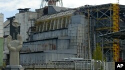 A close view of reactor number 4 of Chernobyl nuclear power plant in this May 10, 2007 picture, with the Chernobyl Monument, left, erected in 2006. Two decades after an explosion and fire at the nearby Chernobyl nuclear power plant sent clouds of radioact