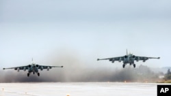 Sepasang jet Su-25 Rusia, lepas landas di pangkalan udara Hemeimeem di Suriah, Rabu, 16 Maret 2016. (Foto: Vadim Grishankin/kanmtor Kemenhan Rusia via AP).