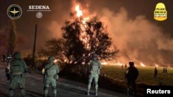 Military personnel watch as flames engulf an area after a ruptured fuel pipeline exploded, in the municipality of Tlahuelilpan, Hidalgo, Mexico, near the Tula refinery of state oil firm Petroleos Mexicanos (Pemex), Jan. 18, 2019.