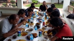 FILE - Indonesian sailors, who were kidnapped by the Abu Sayyaf militant group, eat a meal at a local government official's house after they were released from captivity in Jolo, Sulu in southern Philippines, May 2, 2016.