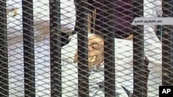 Former Egyptian President Hosni Mubarak is wheeled into a holding cell in the court room in the police academy on the outskirt of the capital Cairo, where he faces murder charges, August 3, 2011