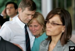 FILE - Andrew Goddard, whose son was wounded during a deadly 2007 shooting at Virginia Tech in 2007, comforts another parent during a 2008 news conference announcing an $11 million state settlement with victims’ families.