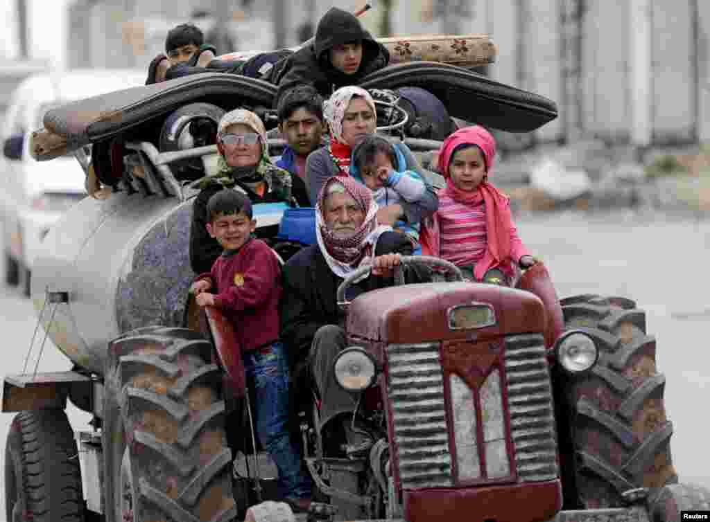 People flee after Turkish-backed Free Syrian Army fighters captured Khaldieh village in eastern Afrin, Syria, March 10, 2018.