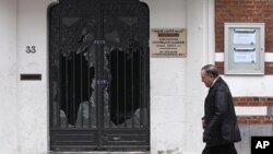 Man walks past damaged door of Reda mosque in Brussels, Belgium March 13, 2012.