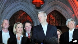 Wikileaks founder Julian Assange (C) stands with his legal team Geoffrey Robertson, (R) Mark Stephens, (3rd L) Jennifer Robinson (2nd L) and spokesman Kristinn Hrafnsson, (L) as he addresses the media outside the High Court in central London, 16 Dec 2010