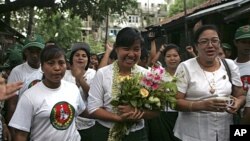 Le Le Aye, center, a candidate of the military-backed Union Solidarity and Development Party (USDP), waves to supporters during her campaign for the April 1 by-election in Rangoon, Burma, March 29, 2012.