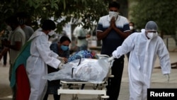 Relatives react as a healthcare worker pulls a stretcher carrying the body of a person, who died from the coronavirus disease (COVID-19), at a mortuary, amidst the spread of the coronavirus disease (COVID-19) in Ahmedabad, India, April 26, 2021. (REUTERS/Amit Dave)