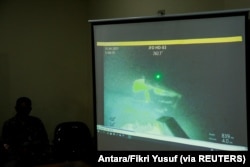 Personel militer menayangkan video yang diyakini sebagai kapal selam TNI AL KRI Nanggala-402 yang tenggelam saat jumpa pers di Bandara I Gusti Ngurah Rai, Bali, 25 April 2021. (Foto: Antara/Fikri Yusuf via REUTERS)