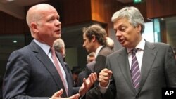 Menlu Inggris William Hague (kiri) berbincang dengan Menlu Belgia Didier Reynders, dalam pertemuan Menlu Uni Eropa di kantor pusat Uni Eropa di Brussels (27/5). Tiga pertemuan terpisah digelar di Brussels dan Paris untuk membahas solusi krisis di Suriah.