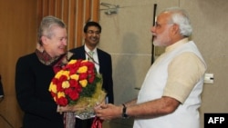 Menteri ibukota negara bagian Gujarat, dan ketua partai Bharatiya Janata (BJP) yang dicalonkan menjadi Perdana Menteri India Narendra Modi (kanan) menyerahkan rangkaian bunga kepada Dubes AS di India, Nancy Powell (kiri) saat bertemu di Gandhinagar, wilayah barat negara bagian Gujarat (13/2).