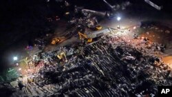 In this aerial photo, a collapsed factory is seen with workers searching for survivors, Dec. 11, 2021, in Mayfield, Ky., after tornadoes came through the area the previous night.