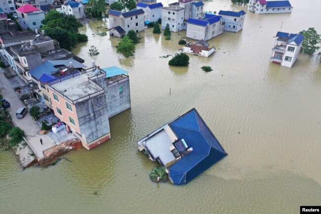 中国江西省鄱阳湖附近村庄被淹一房屋被洪水冲倒。（2020年7月13日）