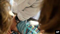 Dokter Roberto Ieraci sedang memvaksinasi seorang anak di Roma, 23 Februari 2018.