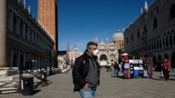 Un hombre camina portando una máscara en la Plaza San Marcos, Venecia.