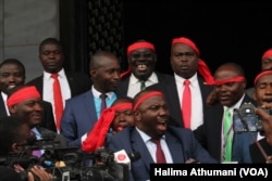 Ugandan opposition legislators sing outside the Parliament building in Kampala, Uganda, Sept. 21, 2017, after a motion to amend the Constitution failed. They left Parliament singing and said every day the Constitution remains untouched is a win.