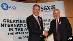 Magnus Bocker (L), CEO of the Singapore Exchange (SGX), shakes hands with Robert Elstone (R), CEO of the Australian Stock Exchange (ASX), in Sydney, 25 Oct 2010