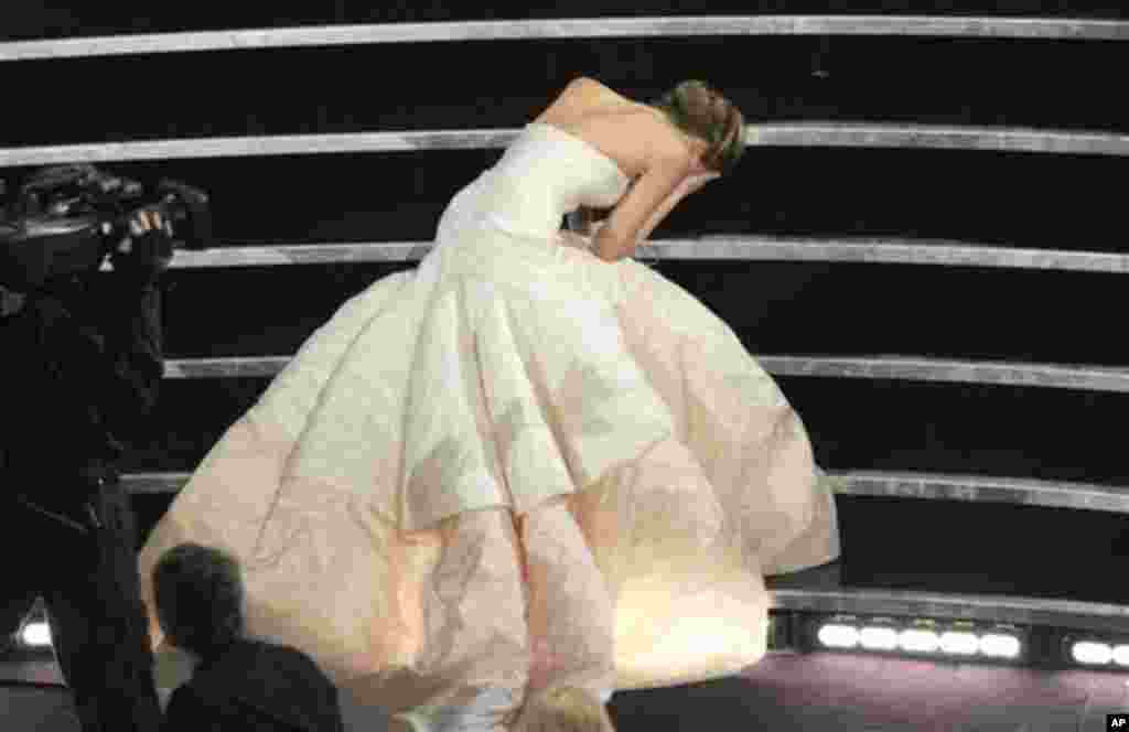 Aktris Jennifer Lawrence tersandung dan jatuh saat berjalan ke panggung untuk menerima penghargaan aktris terbaik untuk film &quot;Silver Linings Playbook&quot; pada Academy Awards ke-85 di Dolby Theatre, Los Angeles (24/2). (AP/Chris Pizzello/Invision)