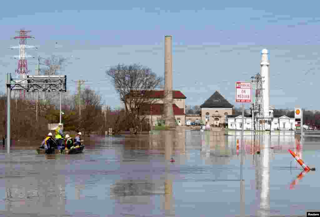 Para pekerja perusahaan listrik berusaha mematikan aliran listrik di sepanjang sungai Ohio setelah banjir melanda kota Louisville, Kentucky, AS.