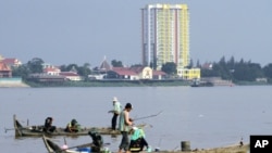 People fish on wooden boats on the Mekong River in Phnom Penh August 19, 2010. More than 60 million people live in the Lower Mekong Basin, an area of more than 600,000 square kilometers. It is the world's largest inland fishery.