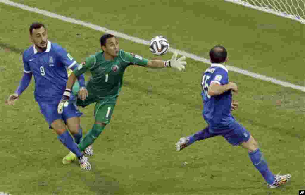 Costa Rica's goalkeeper Keylor Navas tries to catch the ball beside Greece's Kostas Mitroglou, left, and Vasilis Torosidis during the World Cup round of 16 soccer match between Costa Rica and Greece at the Arena Pernambuco in Recife, Brazil, Sunday, June 