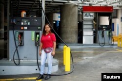 Yanis Reina, 30, a gas station attendant, poses for a photograph at a gas station in Caracas, Venezuela, Feb. 24, 2017.