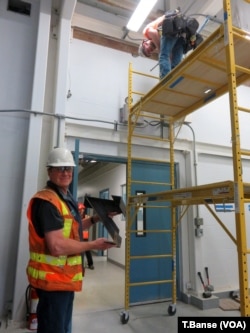 Contractor at work preparing to brace the walls and ceiling joints to earthquake-proof the operations building at Everett's drinking water source.