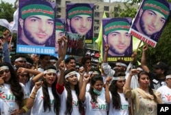 Members of a Kashmiri youth group hold posters of young rebel leader Burhan Wani, killed by Indian troops last year, while chanting anti-Indian slogans during a rally to mark the first anniversary of his death, in Lahore, Pakistan, July 8, 2017.