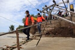 Kepala BNPB Letnan Jendral TNI Dr. (H.C.) Doni Monardo (kiri depan) menyeberangi jembatan darurat di Desa Taramana, Kepulauan Alor, NTT, Rabu (7/4). (Foto: Twitter/BNPB)