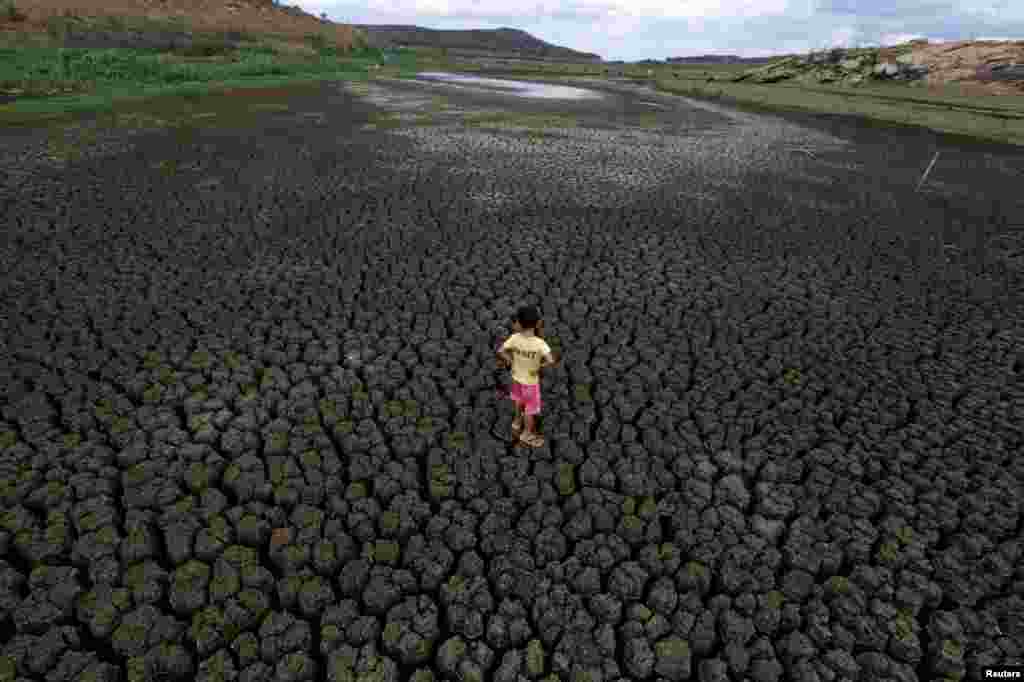 Seorang anak berdiri di lokasi waduk Boqueirao yang kering akibat kemarau di Campina Grande, Paraiba, Brazil.