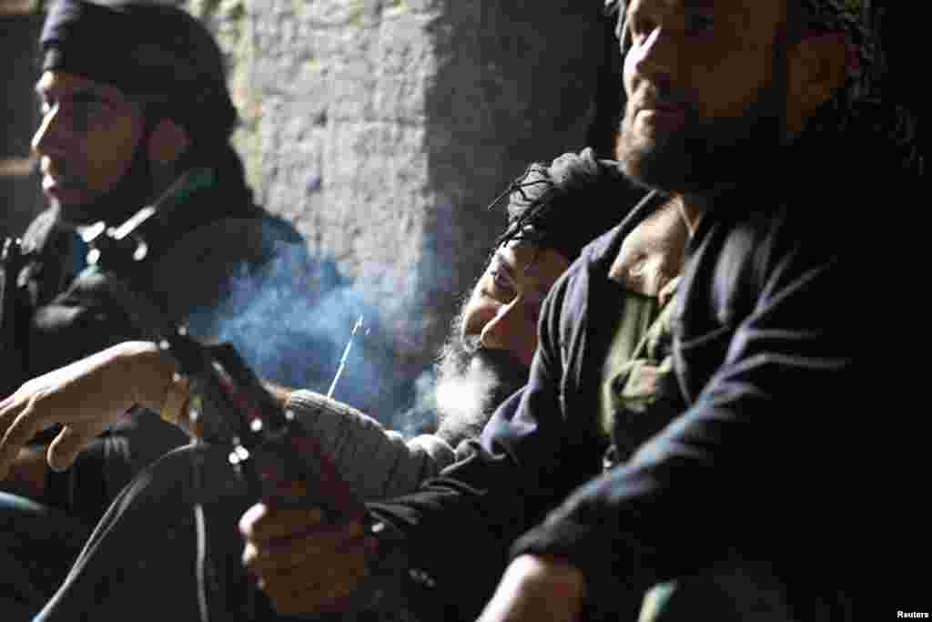 A fighter from the Aoun-bi-allah Brigade, which operates under the Free Syrian Army, takes a smoke break in Aleppo, March 16, 2013.