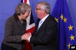 British Prime Minister Theresa May, left, is greeted by European Commission President Jean-Claude Juncker at EU headquarters in Brussels, Dec. 11 2018.