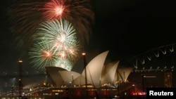 FILE - Fireworks explode over the Sydney Opera House in a display before the midnight fireworks that will usher in the new year in Australia's largest city, Dec. 31, 2015.