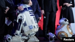 Mark Hamill, a cast member of the movie "Star Wars: The Last Jedi," hugs character R2-D2 during promotional event in Tokyo, Dec. 6, 2017.