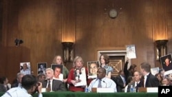 Family members hold picture of miners killed in US mining explosion at congressional hearing, 27 Apr 2010
