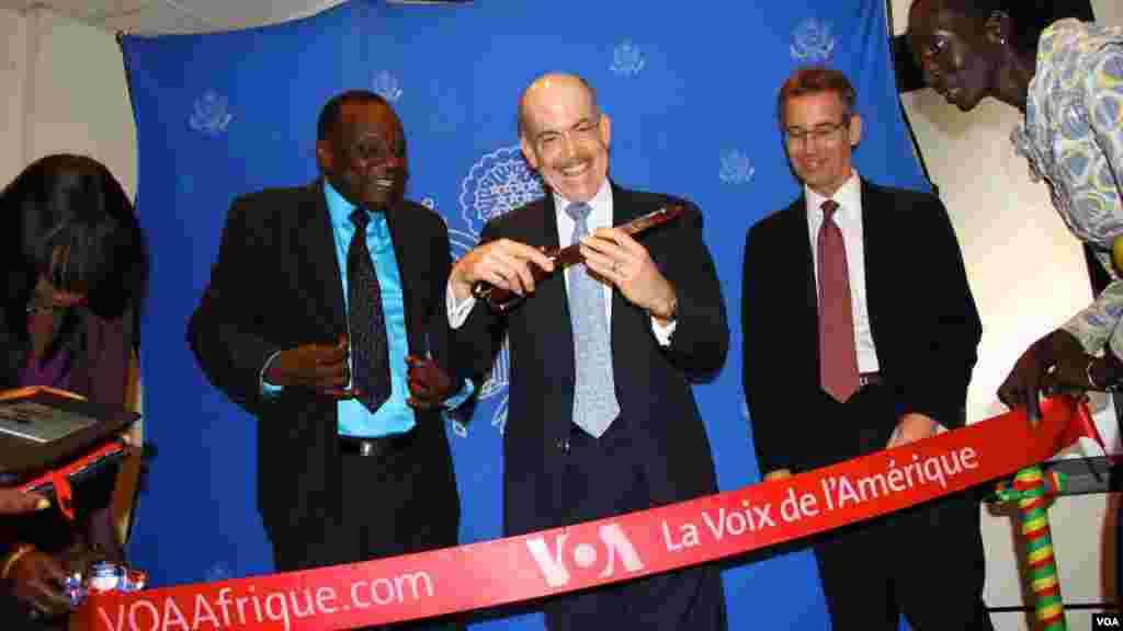 Le ministre sénégalais de la Culture et de la Communication, Mbagnick Ndiaye (à gauche), l&rsquo;ambassadeur américain à Dakar (centre), Zumwalt et le directeur du Bureau de la stratégie et du développement de Broadcasting Board of Governors, Bruce Sherman coupent le ruban symbolique lors du lancement de loa fréquence 102 FM de la VOA Afrique à Dakar, Sénégal, mardi 3 mars 2015.