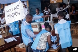 Election officials count ballot papers cast at a polling station in Freetown, Sierra Leone, March 7, 2018.