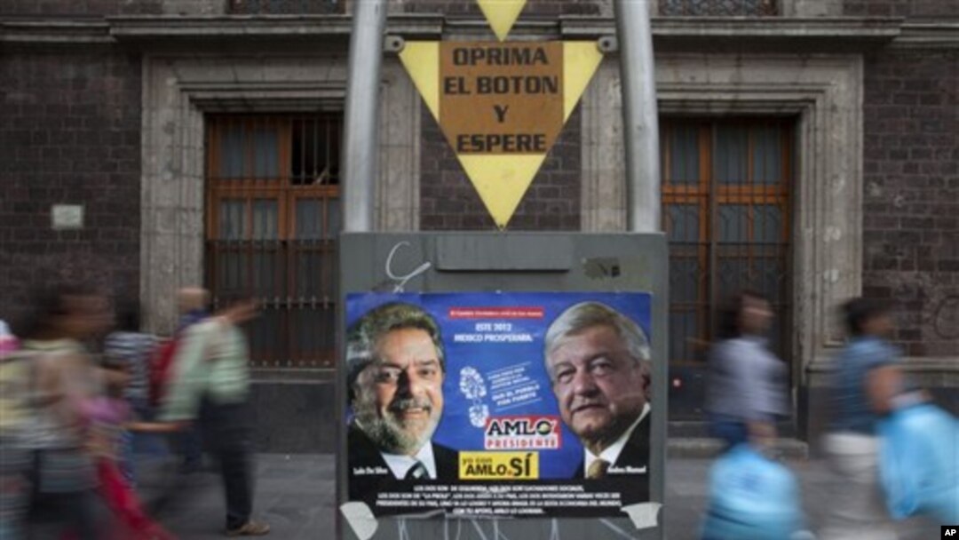 Poster kampanye pemilu presiden Meksiko bergambar capres Andres Manuel Lopez Obrador (kanan) dari partai Revolusi Demokratik (PRD), dan mantan presiden Luiz Inacio Lula da Silva, di pojok kota Meksiko (29/6).