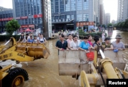 水淹武汉，人们利用挖土机前去上班（2016年7月8日）
