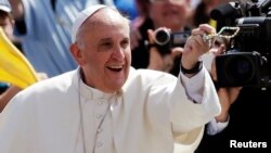 Pope Francis catches a rosary thrown by faithful as he arrives to lead his Wednesday general audience in Saint Peter's Square at the Vatican, June 5, 2013. 