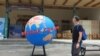 Sebuah bola dunia di pusat kota Yogya yang menjadi bagian dari kampanye mewaspadai corona. (Foto:VOA/Nurhadi Sucahyo)