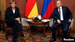 FILE - Russian President Vladimir Putin meets with German Chancellor Angela Merkel in Deauville, Northern France, June 6, 2014.